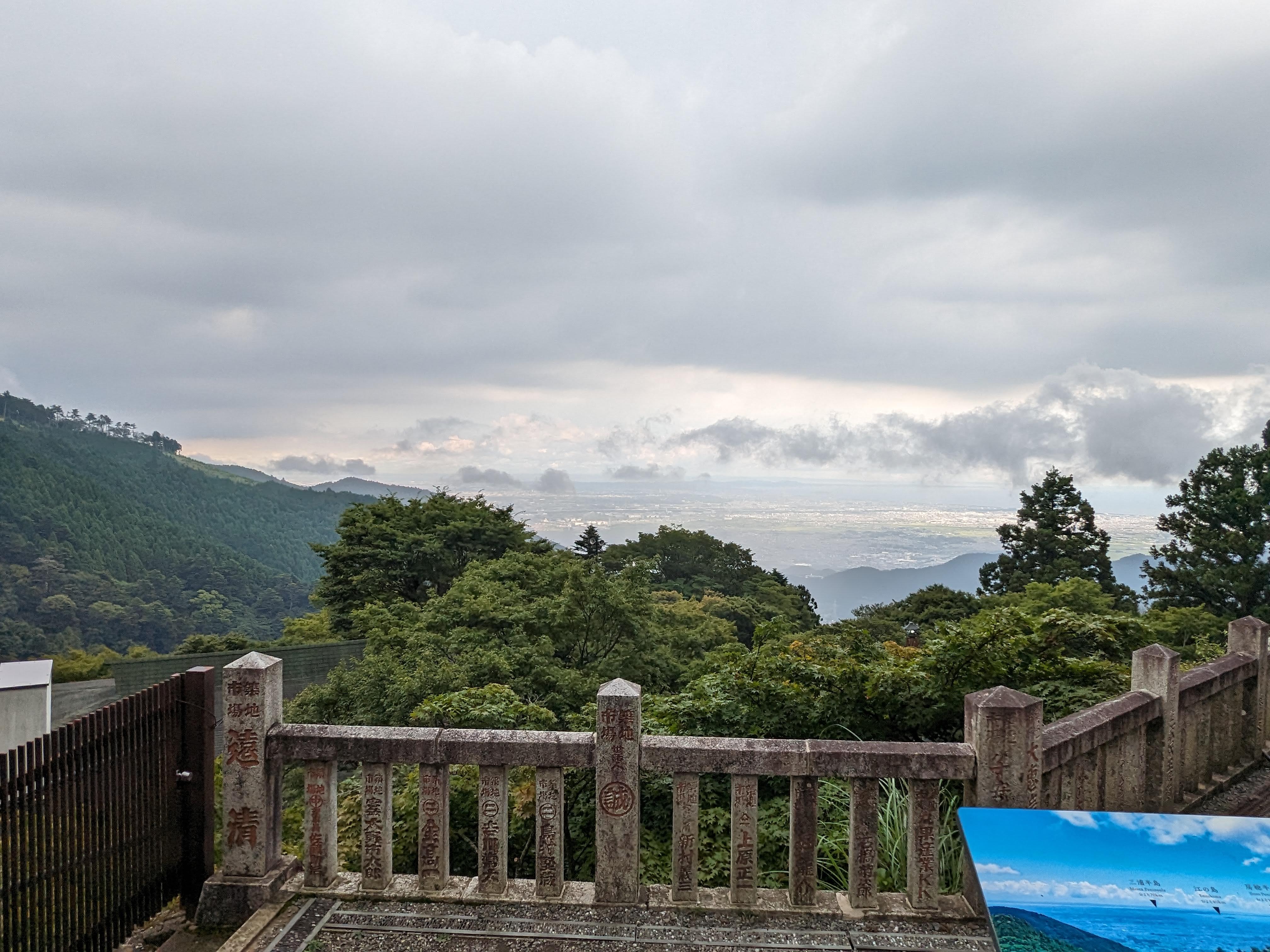 阿夫利神社下社の石欄干越しに曇天の相模平野と山の稜線を望む展望台