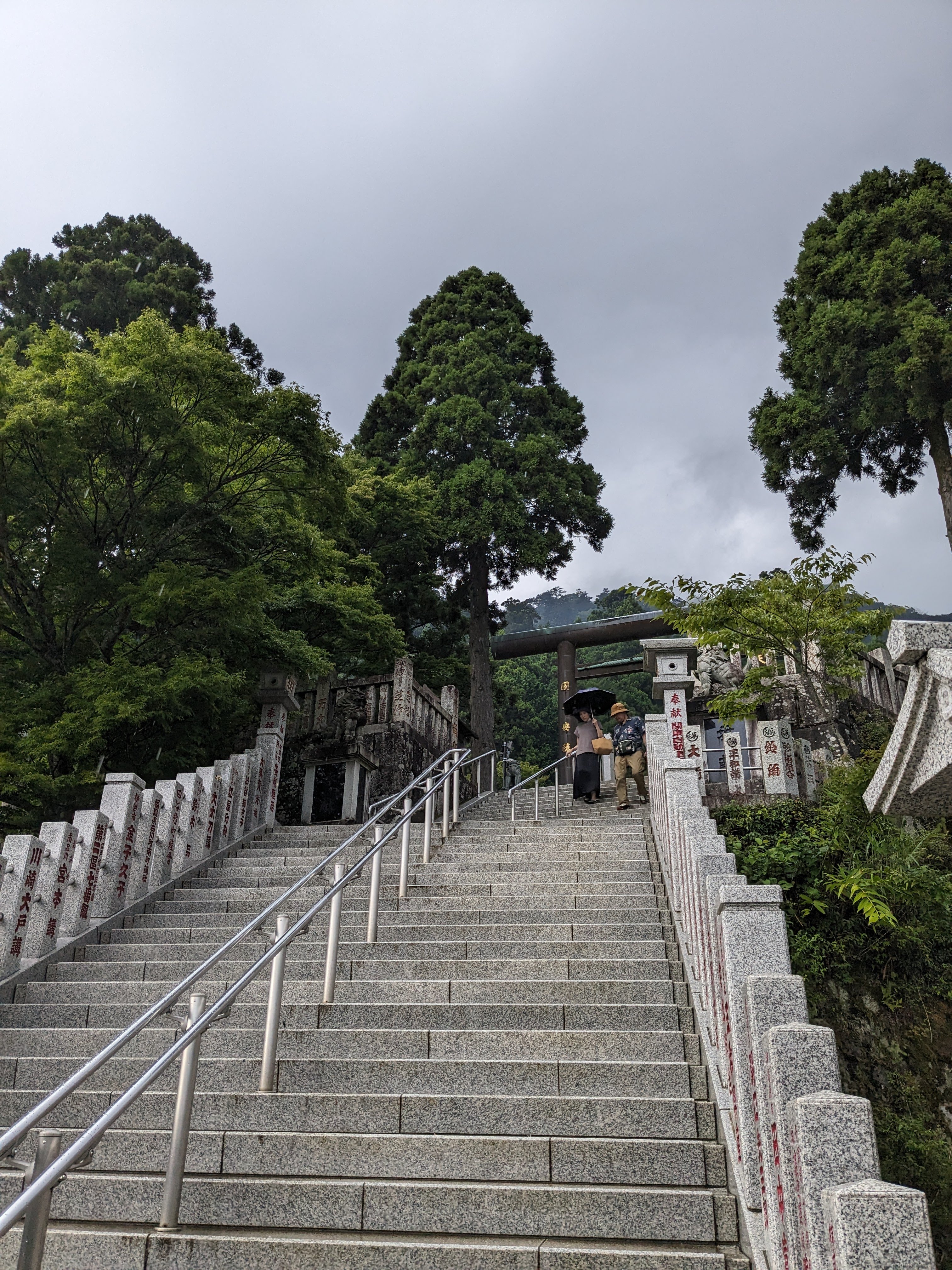 白御影石の大石段が鳥居まで続く阿夫利神社下社の参道。参拝者が上り下りしている